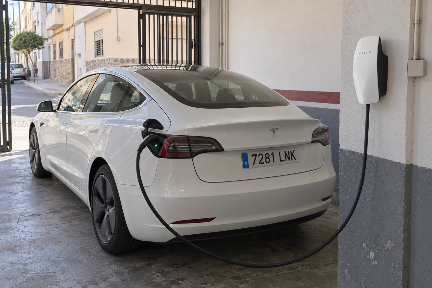 Tesla Model 3 conectado a un cargador en un garaje, escena ilustrativa