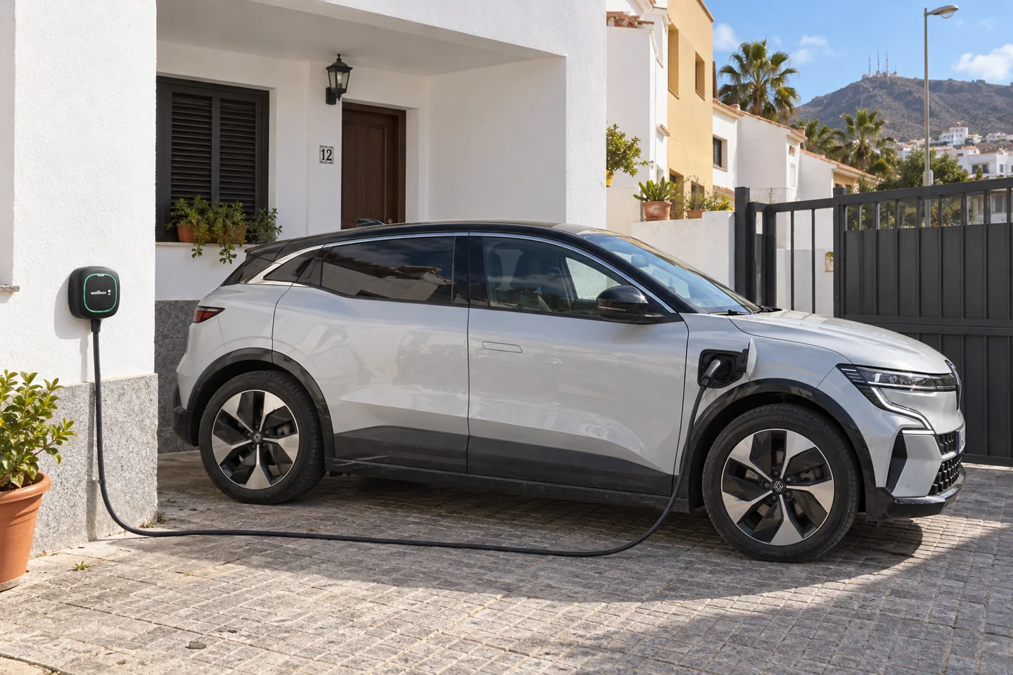 Coche eléctrico aparcado junto al cargador de una vivienda, escena ilustrativa